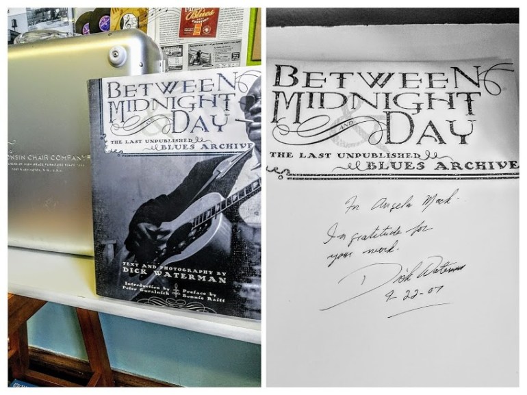 Close-up of the book 'Between Midnight and Day: The Last Unpublished Blues Archive' by Dick Waterman, featuring a black and white photograph of a musician playing guitar on the cover.